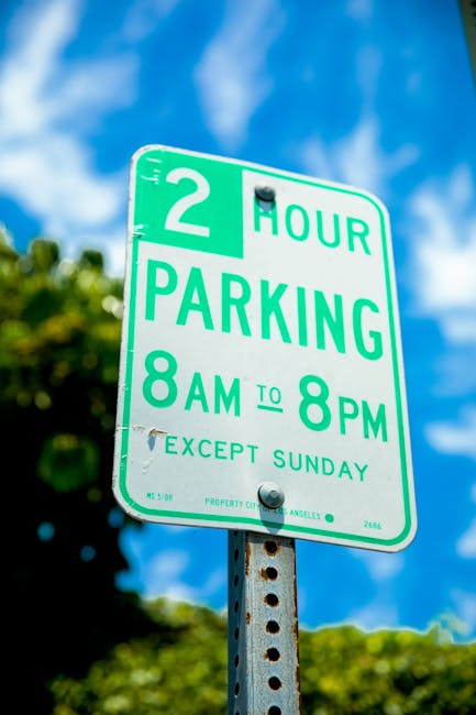 A rectangular outdoor sign mounted on a wooden post in front of a brick wall, indicating parking restrictions for disabled badge holders. The sign features a blue background with a white wheelchair symbol at the top, followed by the text 'Blue badge holders only' in black. Below, there is a large white letter 'P' on a blue background, denoting parking. The sign is positioned at a height suitable for visibility, and the surrounding environment suggests an area adjacent to a residential or commercial property, relevant for home relocation and furniture transport services. The lighting appears natural, casting subtle shadows on the sign and wall, with the sign serving as guidance for parking during a moving process or household removal coordinated by Lambeth Movers according to local parking rules for removals.